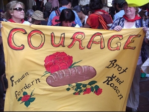 Text vom Transparent: Courage - Frauen fordern Brot und Rosen
